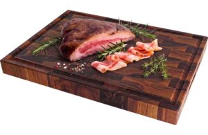 Raw pork roast on a wooden cutting board with rosemary and bacon slices nearby, ready to cook.